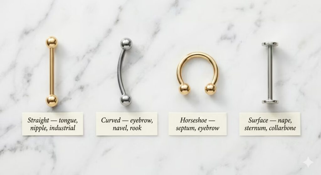 A clean product flat-lay on white marble showing four barbell styles side by side with clear labels. 