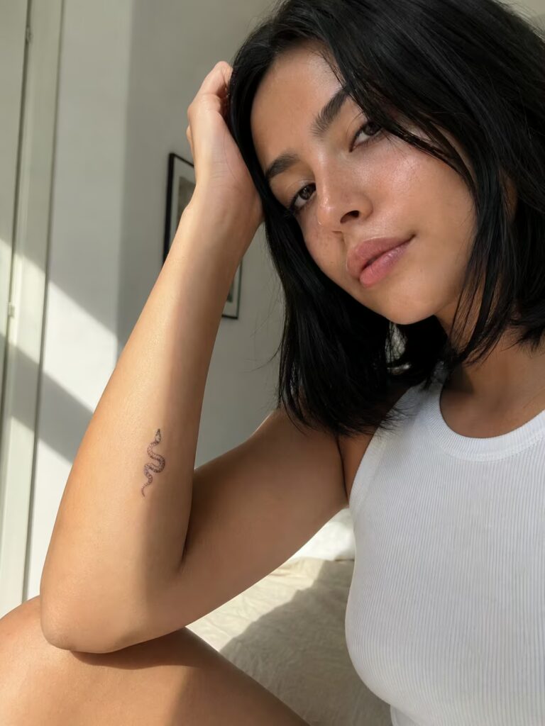 A Tiny Delicate Snake Coiled in a Loose Curve on the Inner Elbow