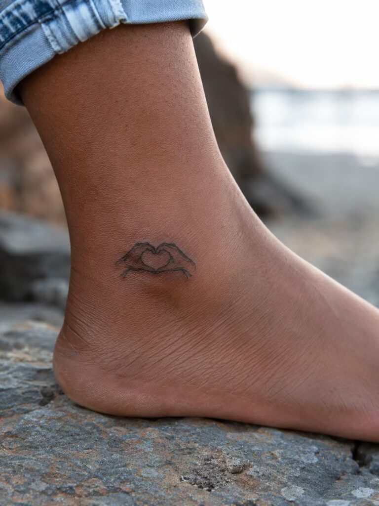 A Small Bestie Tattoo of Two Hands Forming a Heart on the Ankle