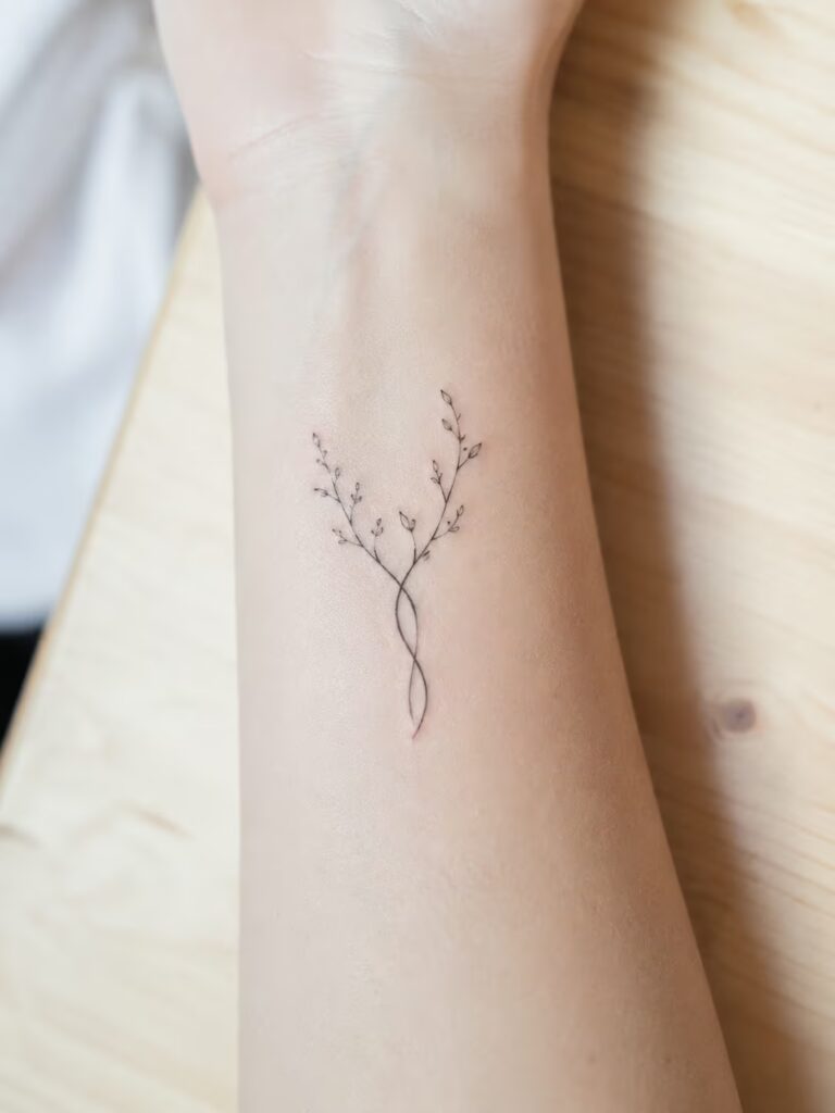 A Small Bestie Tattoo of Two Intertwined Branches on the Inner Wrist