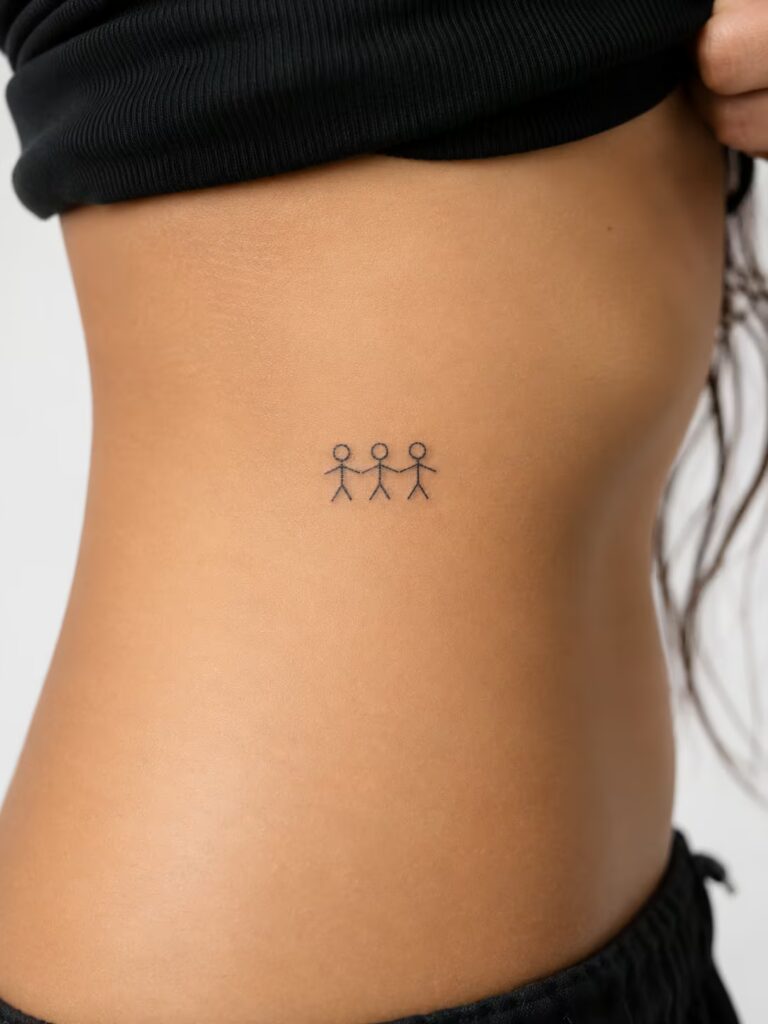 A Small Bestie Tattoo of Three Stick Figures with Linked Arms on the Ribcage